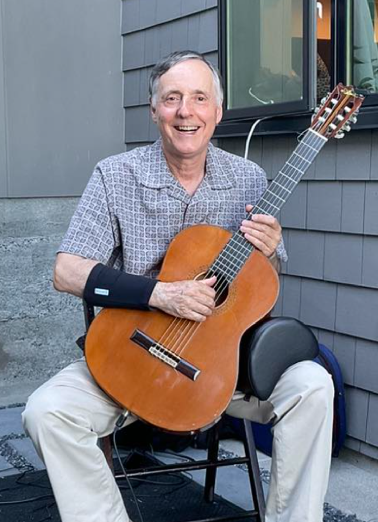 Julian playing the guitar at a summer party